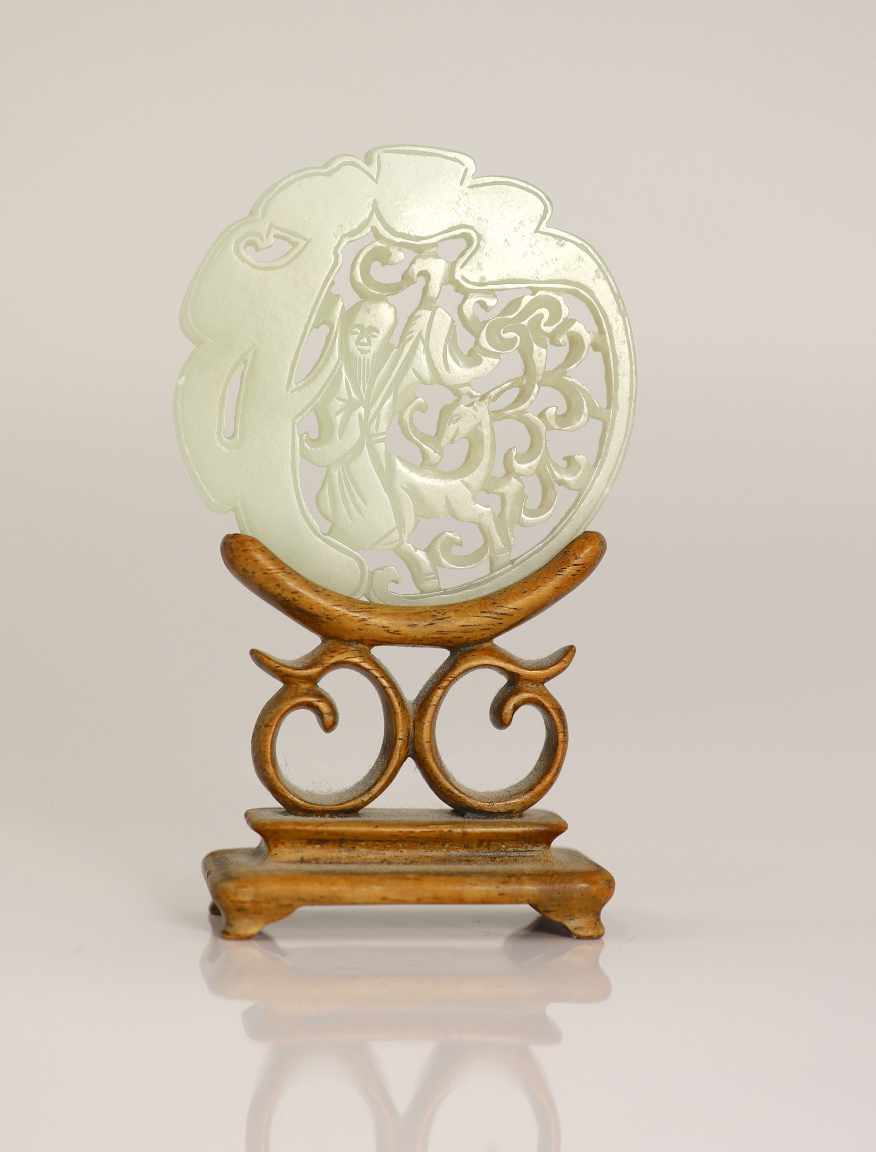 A Chinese pale celadon jade 'Shou Lao' circular plaque, 19th century, 5.3cm, wood stand